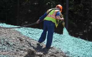 Varsity worker spraying erosion control material