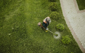 Overhead view of a lawn worker using a weed wacker