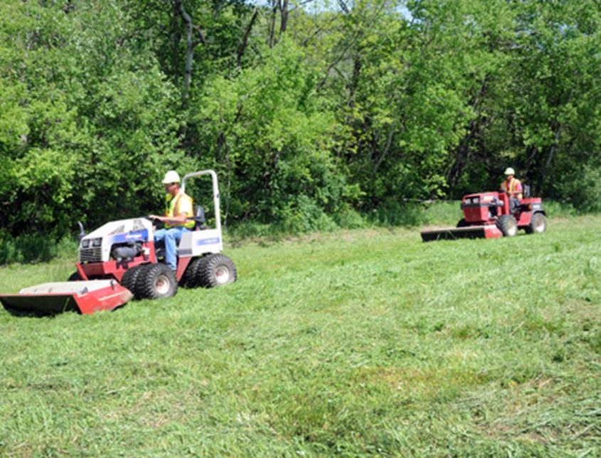 Two Varsity Workers On Riding Mowers 1030x644