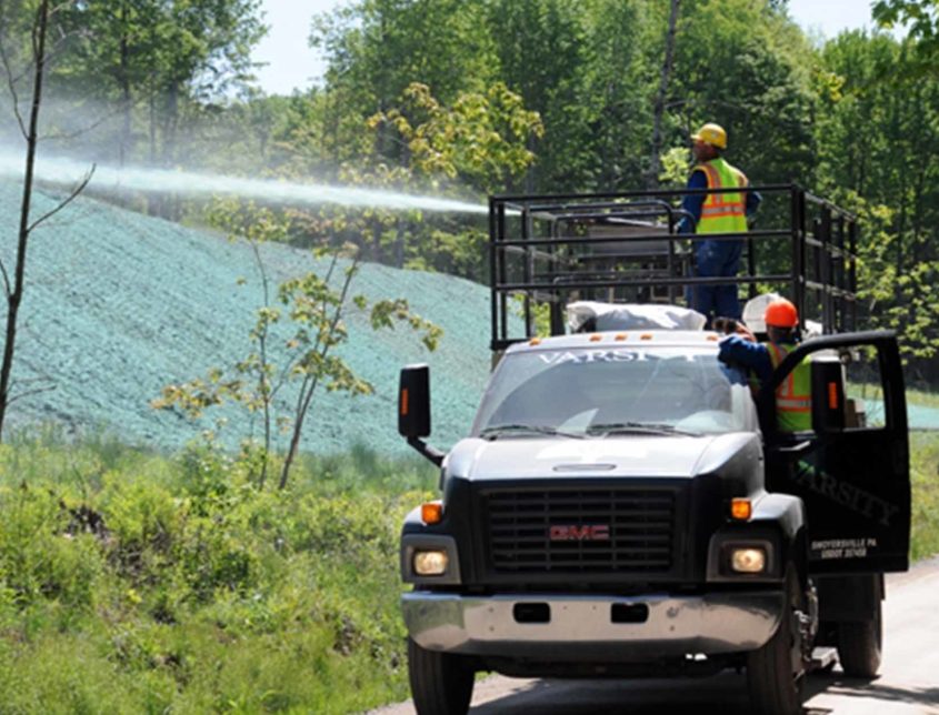 Varsity Crew On A Truck Spraying A Material On A Hilll 1030x644