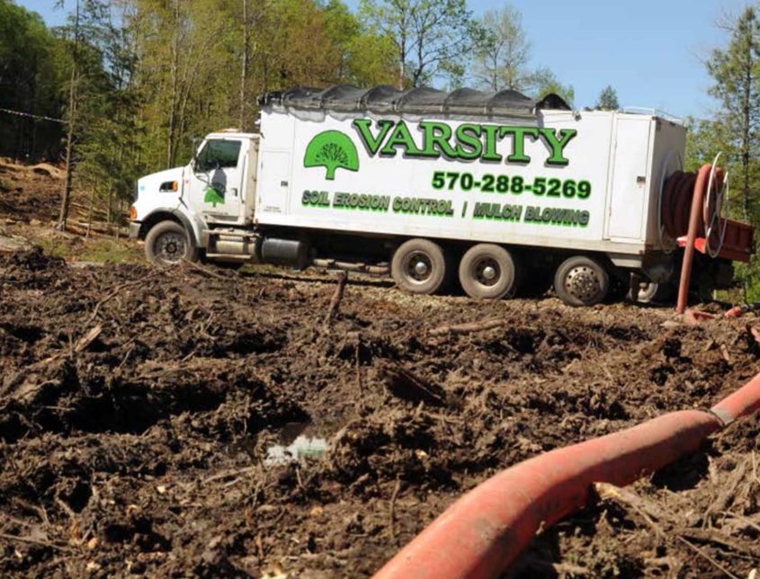 Varsity Dirt Truck Sitting In A Large Clearing 1030x644