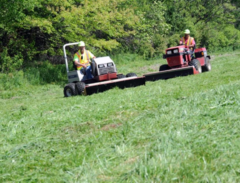 Varsity Land Maintenance Two Workers On Mowers 1030x644